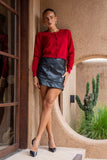 woman wearing red cropped knit cardigan and black leather mini dress standing in crossed legs woman wearing red cropped knit cardigan and black leather mini dress standing in crossed legs