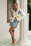 woman wearing a floral knit cardigan leaning on a pillar woman wearing a floral knit cardigan leaning on a pillar