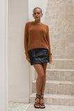 woman wearing brown fluffy knit sweater and black mini skirt standing in front of stairs woman wearing brown fluffy knit sweater and black mini skirt standing in front of stairs