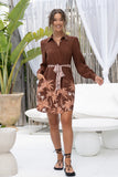 woman posing in brown tropical mini dress