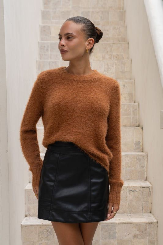woman wearing a brown fluffy knit sweater and black leather mini skirt