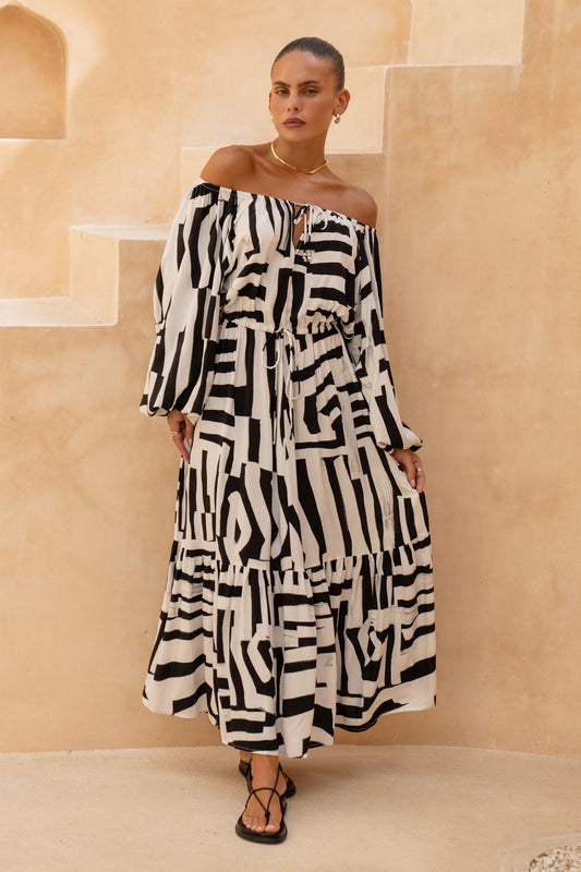 woman wearing a black geometric long sleeve maxi dress