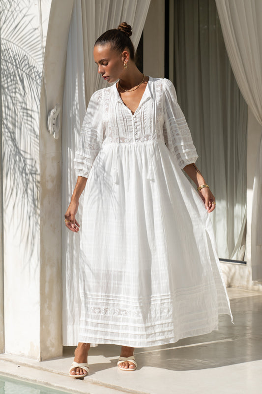 woman showing the hem of a white lace detail maxi dress