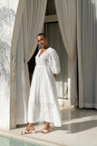 woman standing while wearing a white lace detail maxi dress