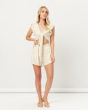 Woman wearing the abi beige tie front linen top
