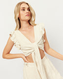 Woman wearing the abi beige tie front linen top