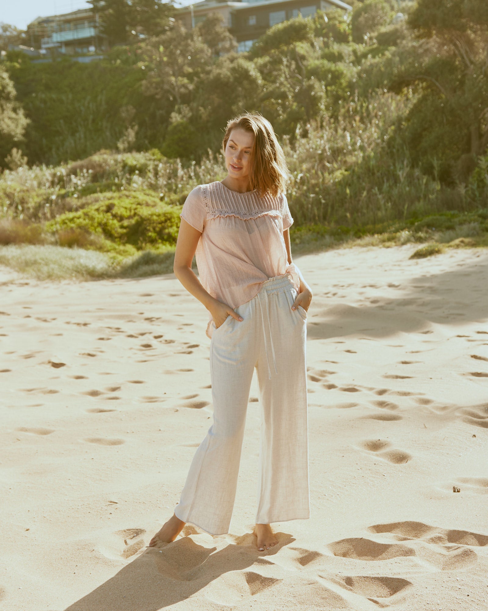 Woman wearing the delilah beige linen pants at the beach