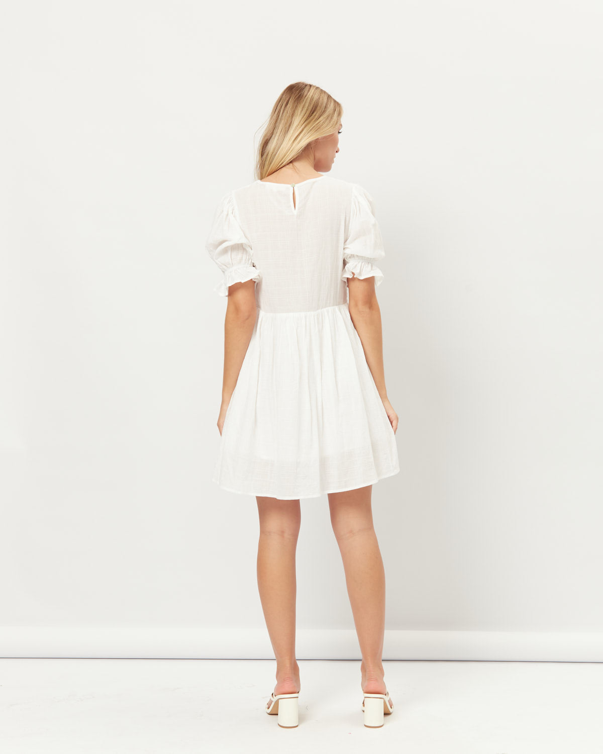 Woman wearing everleigh white puff sleeves mini dress