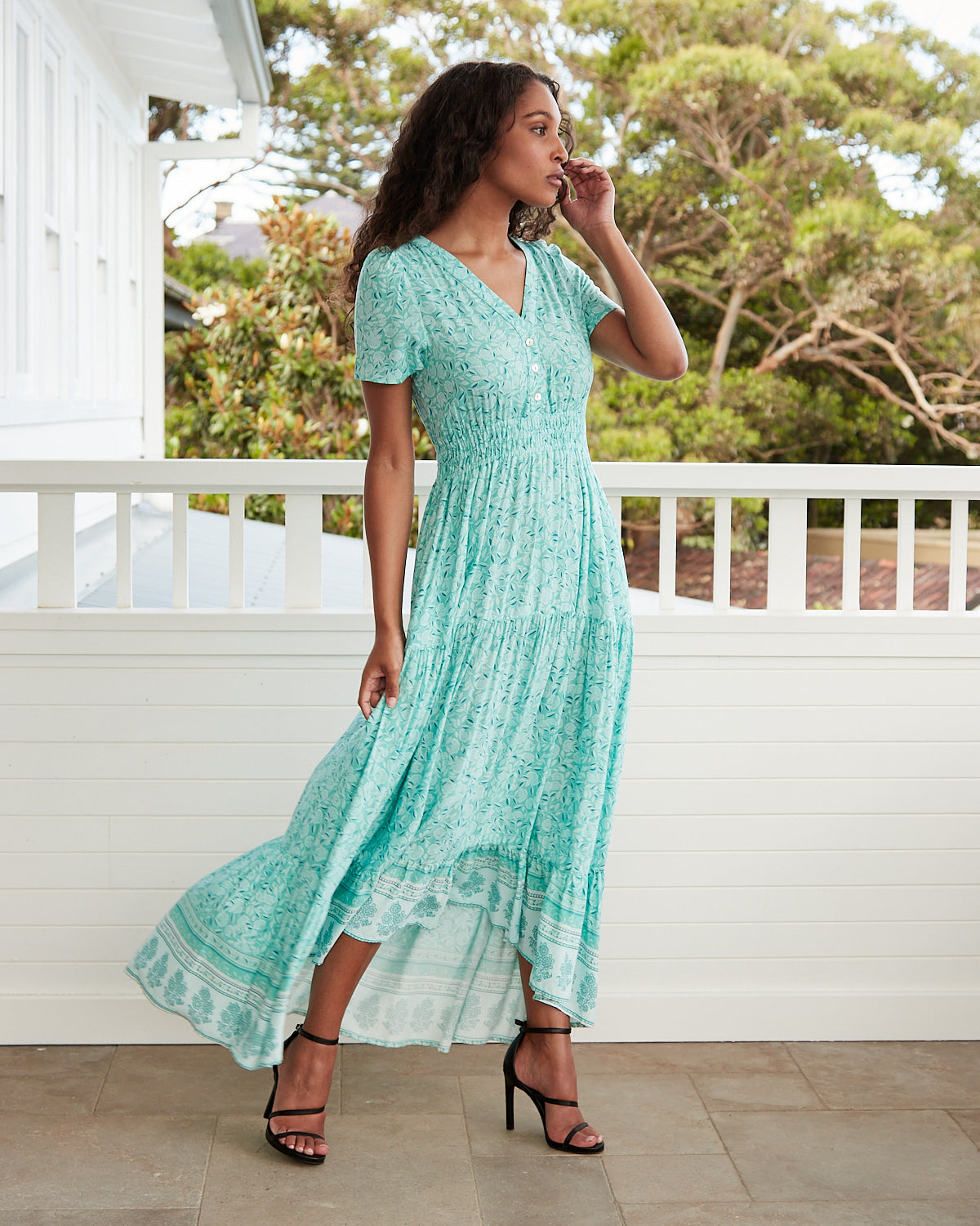 Woman wearing the felicity green floral button down maxi dress
