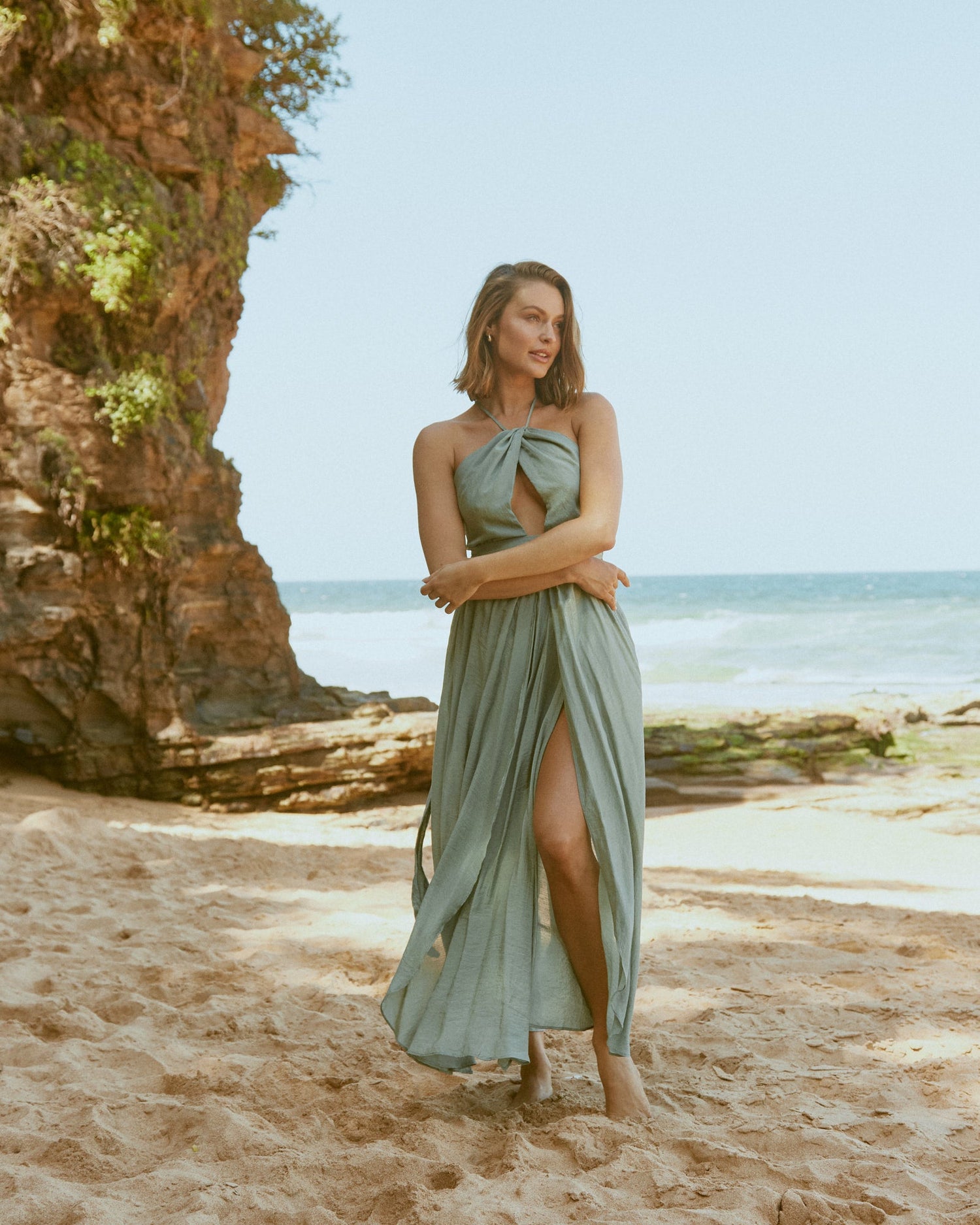 Woman wearing the lana green cut out halter neck maxi dress at the beach