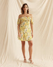 Woman wearing the madison yellow floral puff sleeve mini dress