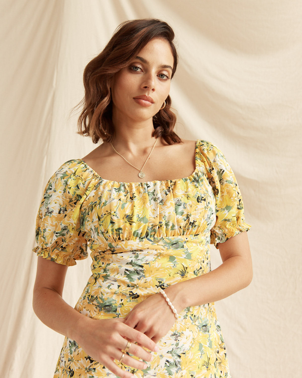 Woman wearing the madison yellow floral puff sleeve mini dress