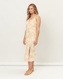 Woman wearing the odessa orange palm leaves midi dress