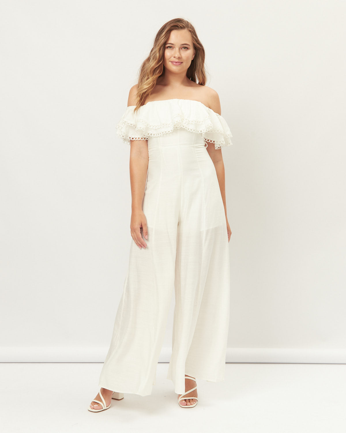 Woman wearing the oona white off shoulder jumpsuit