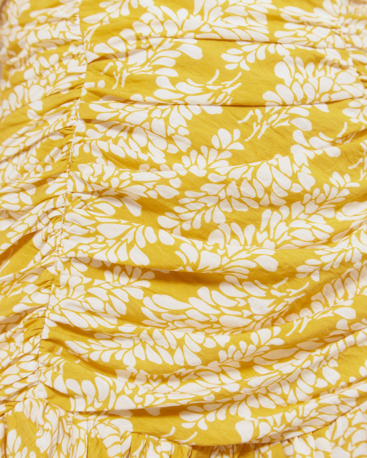Close up of the taya co-ord ruched flippy mini skirt in yellow floral