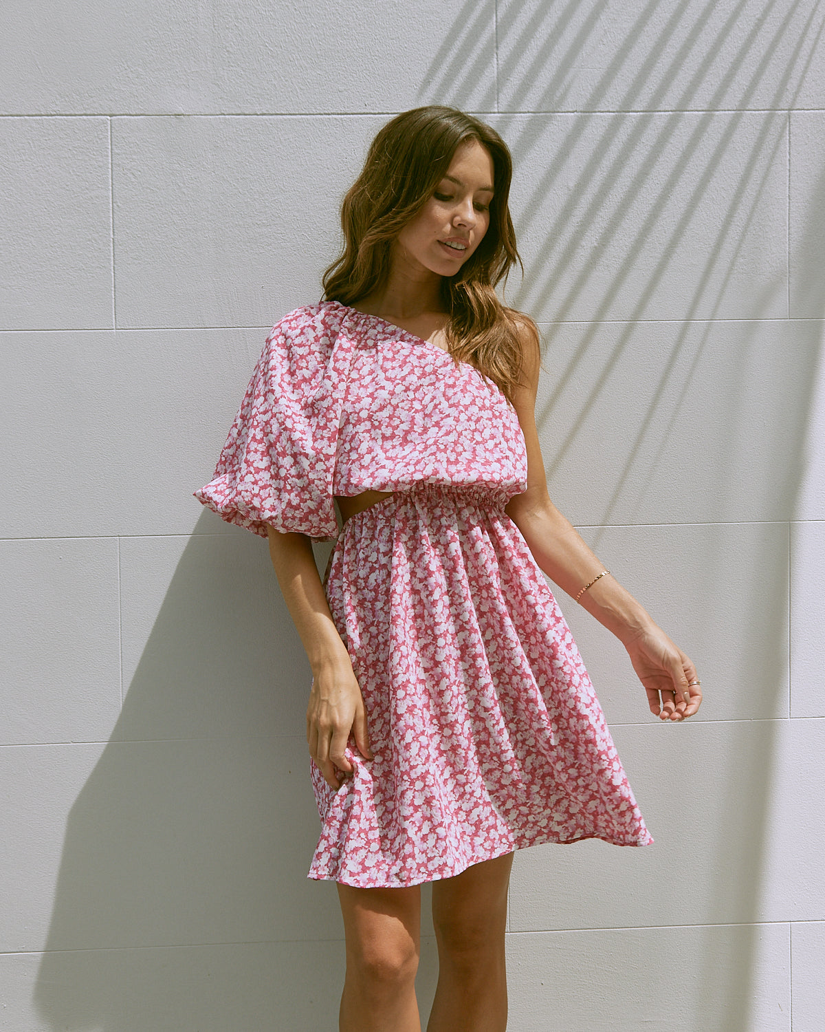 Woman wearing the tessa one shoulder pink floral mini dress