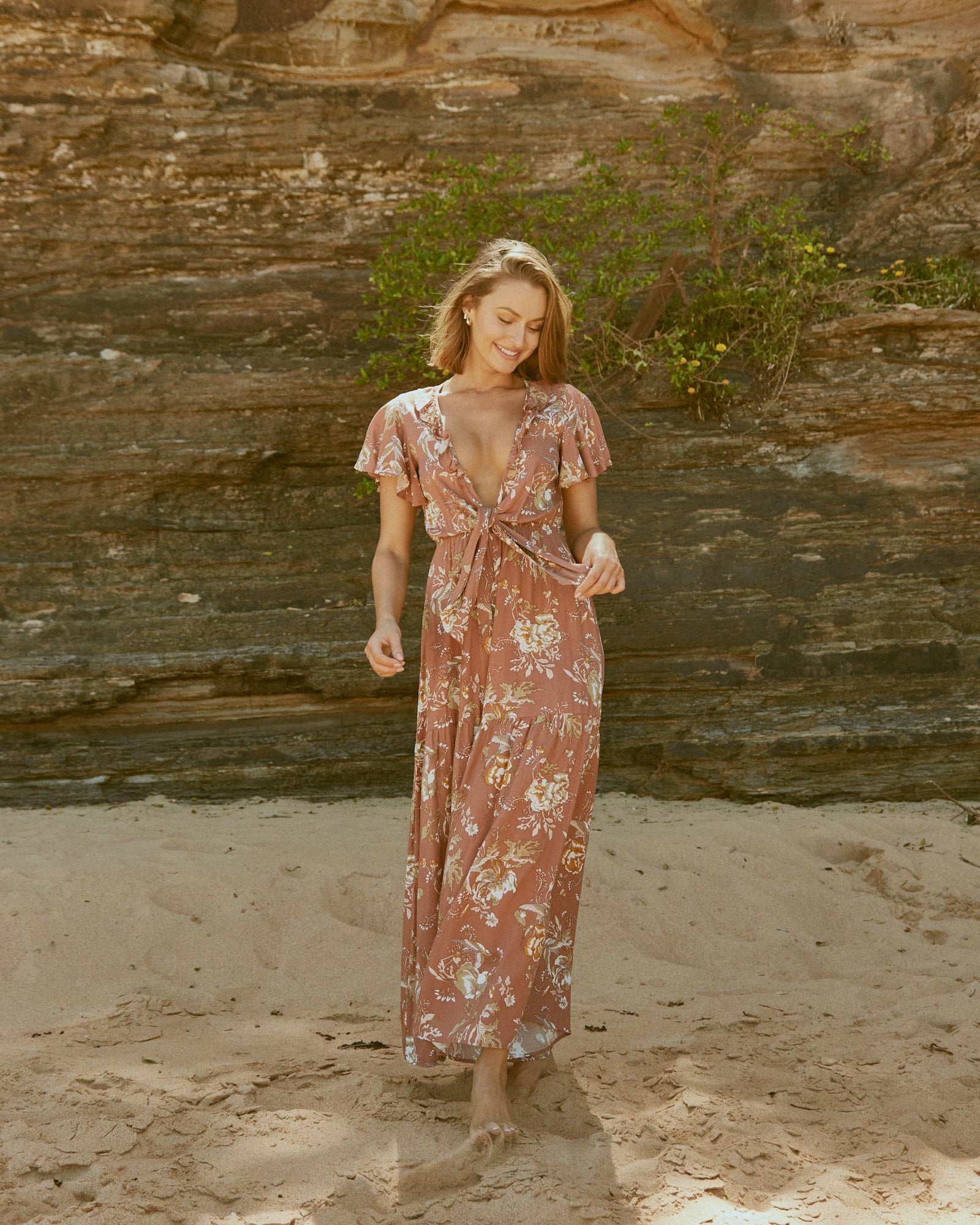 Woman wearing una v neck floral jumpsuit at the beach
