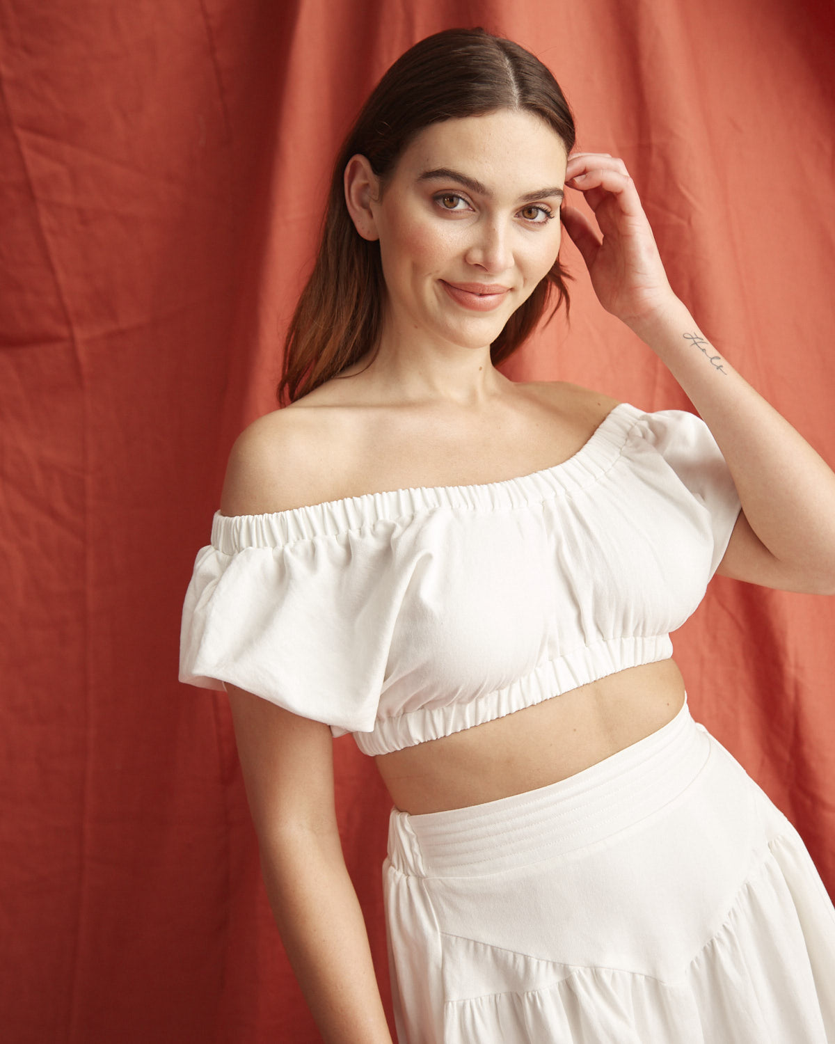 Woman wearing the vienna off shoulder white top